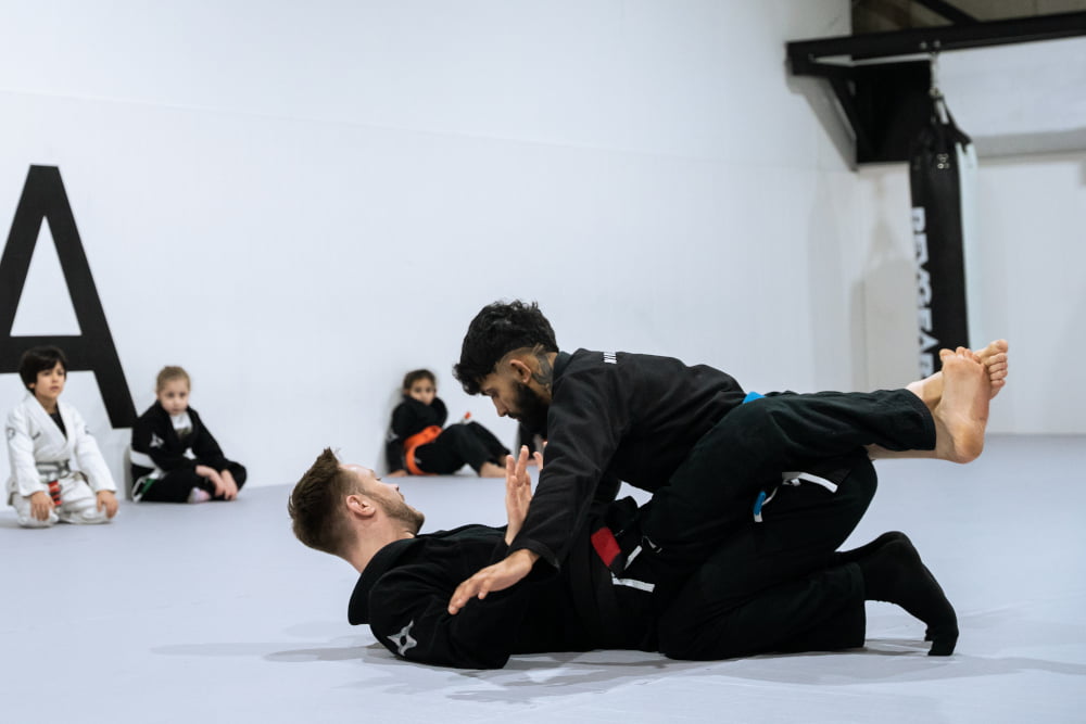 Two Ninja School martial arts instructors demonstrate a jiu jitsu technique.